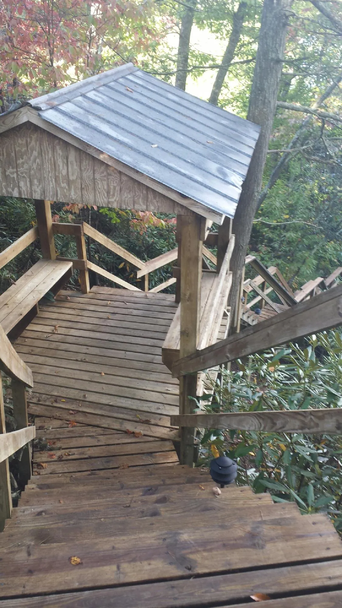 Metal roofed shelter over wooden steps on a wooded walkway — Skylight Repair & Installation work by our crew in Chelan Falls